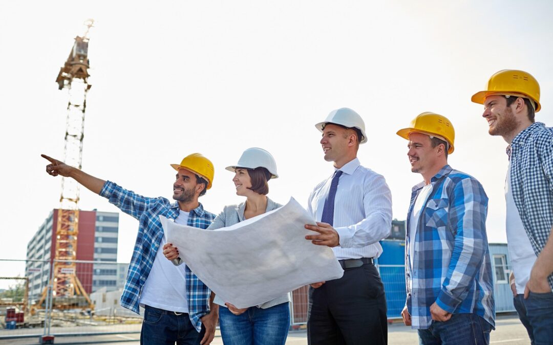 Engineers at a construction site are looking at their project plan.